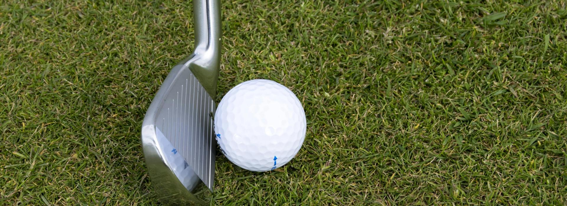 Image of golf ball on tee on grass.